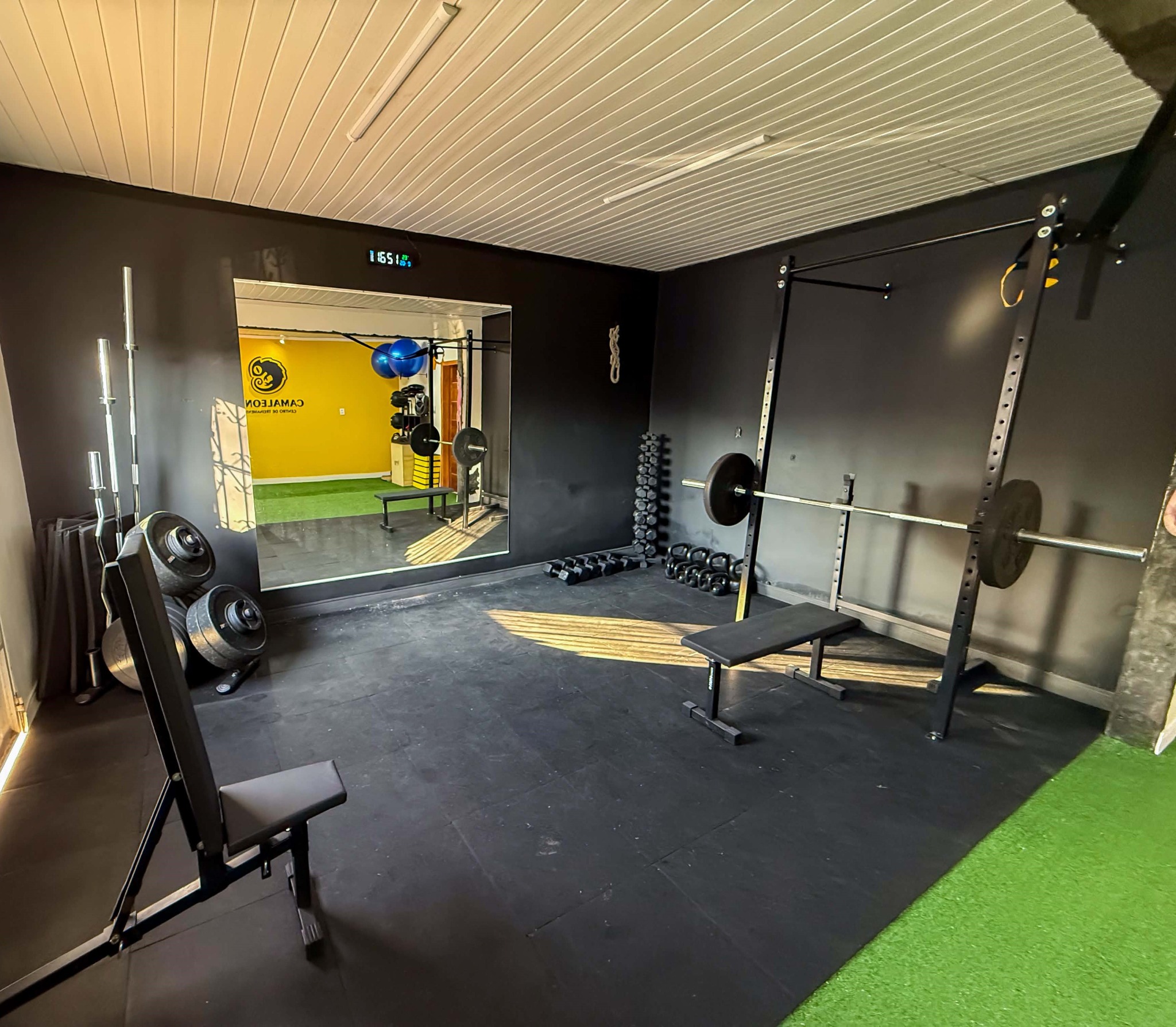 Área de força do CT Camaleones com rack, barras, halteres e kettlebells